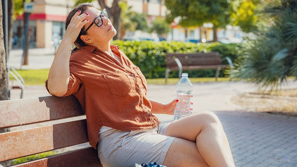 woman sits outside in summer heat
