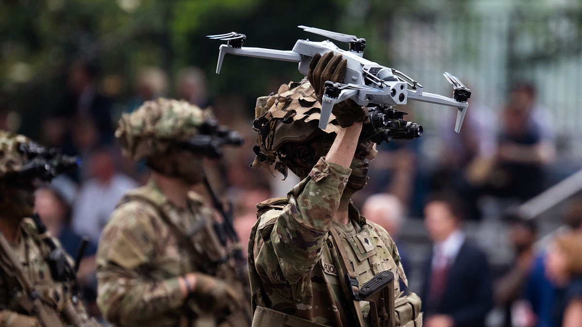 A worker  holds a drone successful  the U.S. Army's 250th day  parade