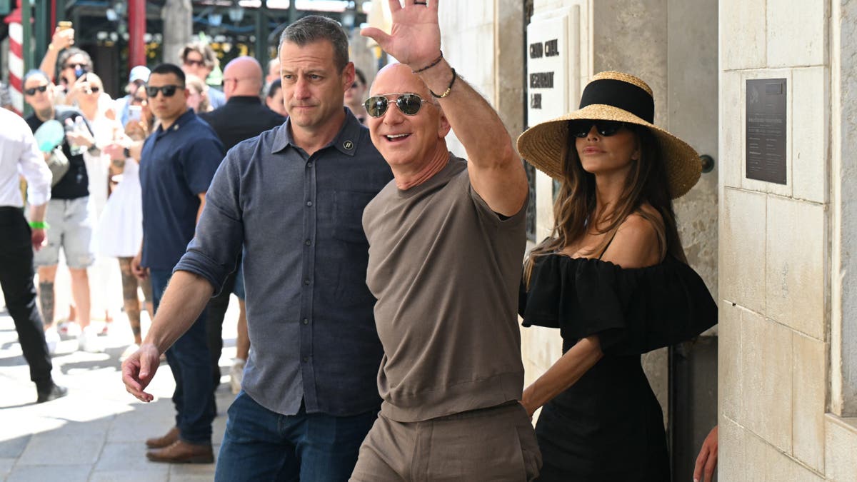 Jeff Bezos waving with Lauren Sanchez