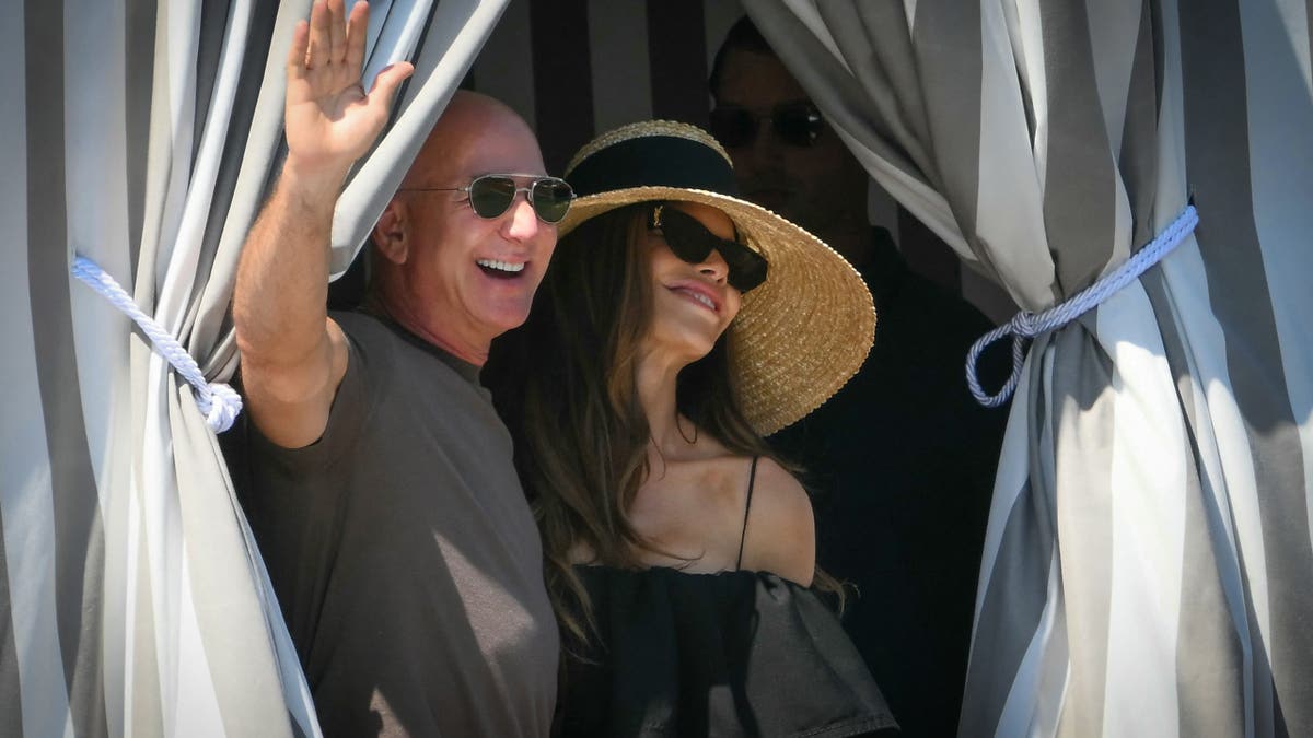 Jeff waving with Lauren Bezos