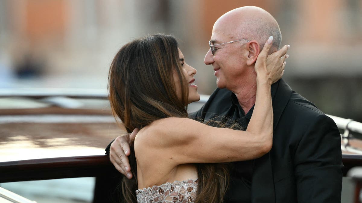 lauren sanchez and jeff bezos smile at each other while embracing after venice wedding