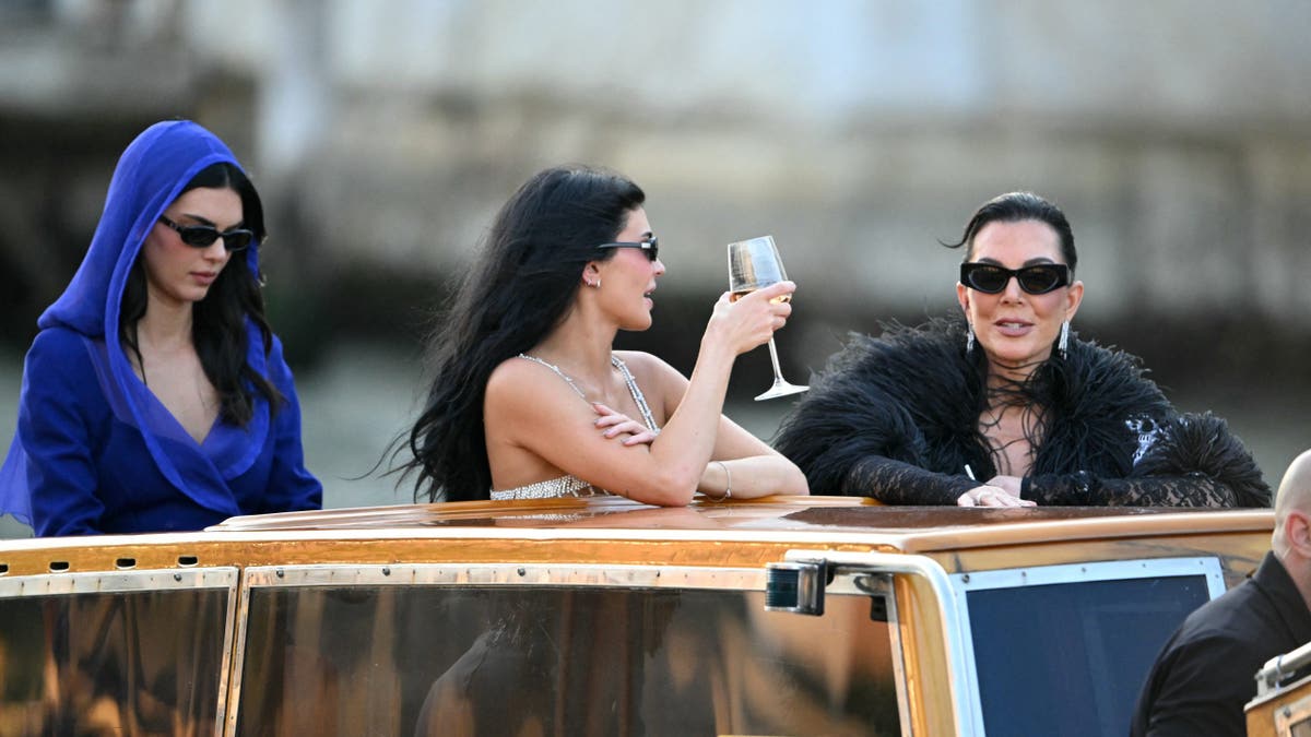 kylie jenner hold a glass of rose while riding a water taxi with kris jenner and kendall jenner