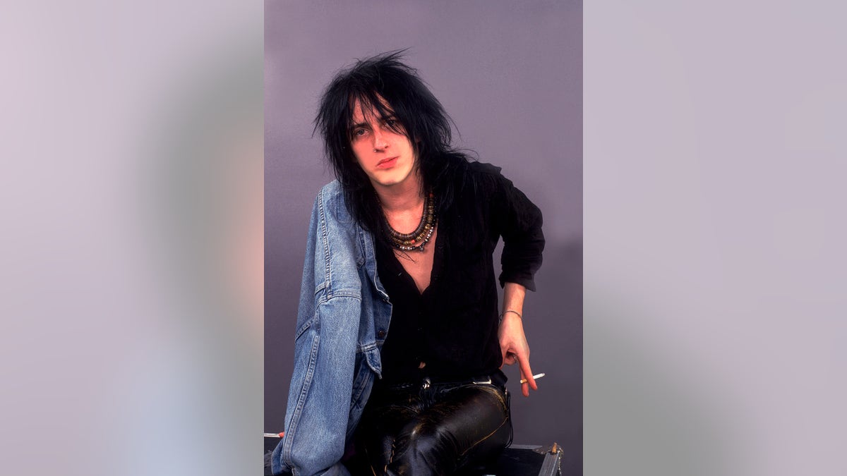 Izzy Stradline wearing each achromatic pinch a jean overgarment arsenic he holds a cigarette.