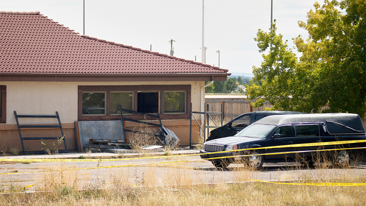 A hearse and van sit outside the Return to Nature Funeral Home