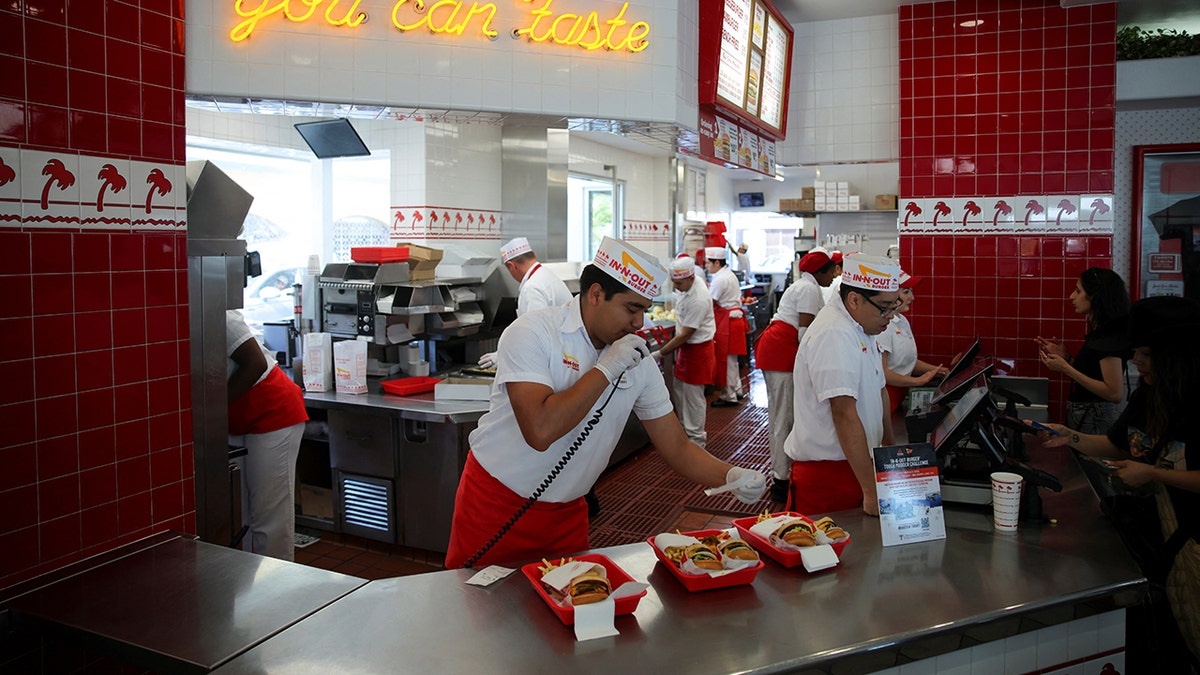 In-N-Out Burger employees serve customers.