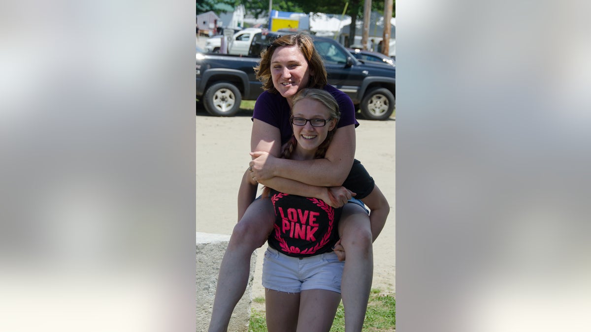 Emily Ferlazzo giving a woman a piggyback ride.