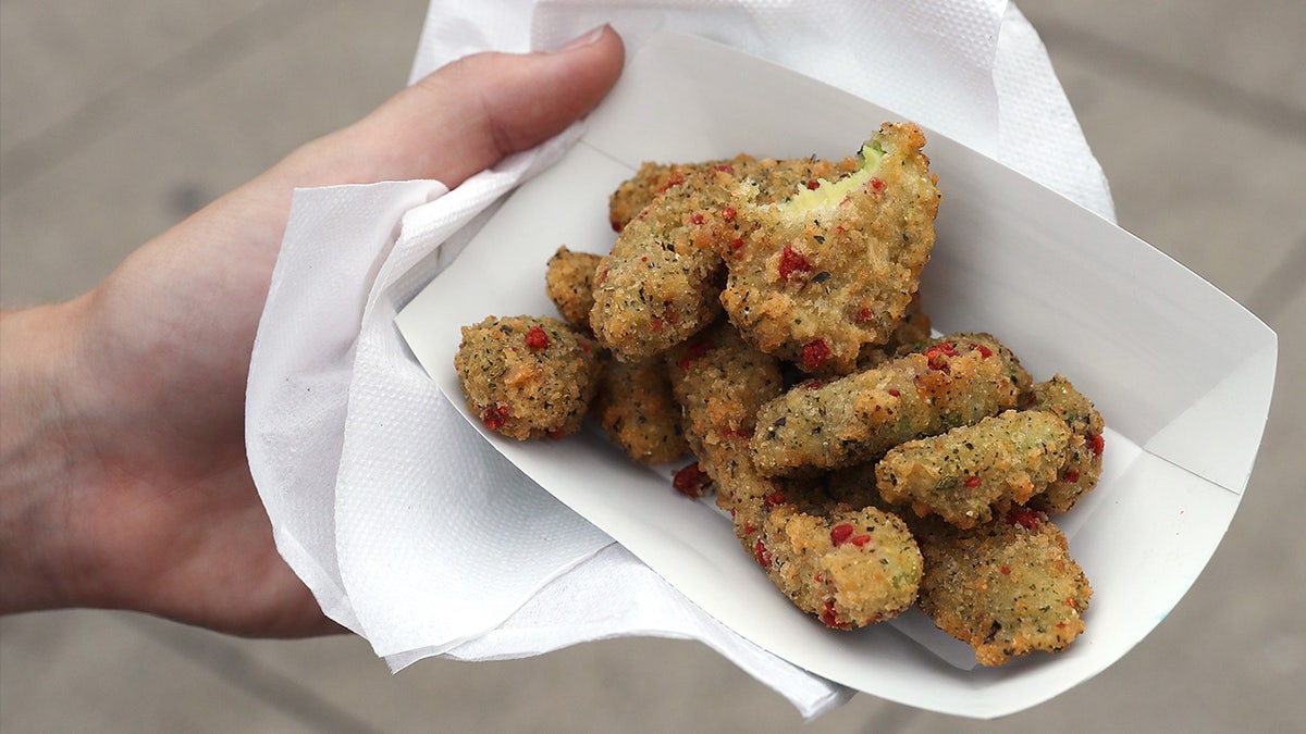 Person holding deep fried avocado slices