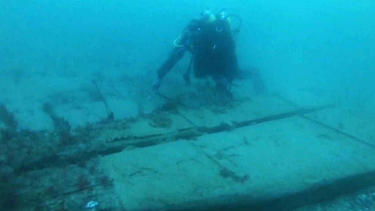 Diver surveying shipwreck site