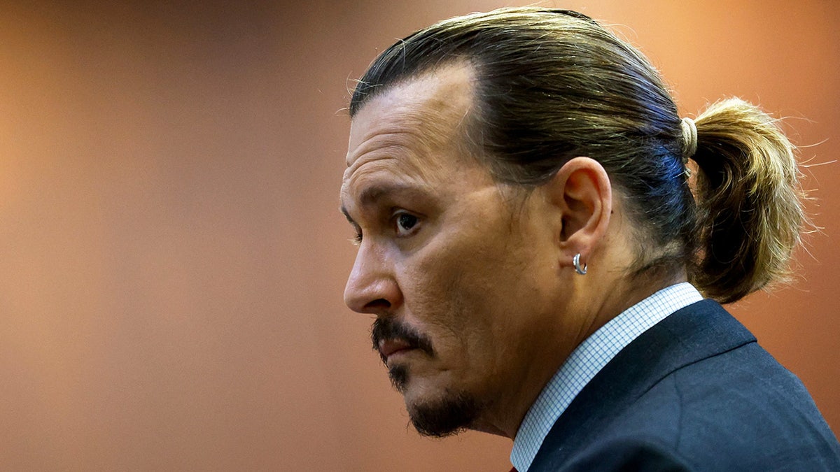Johnny Depp looking concern as he faces to the side of the camera.