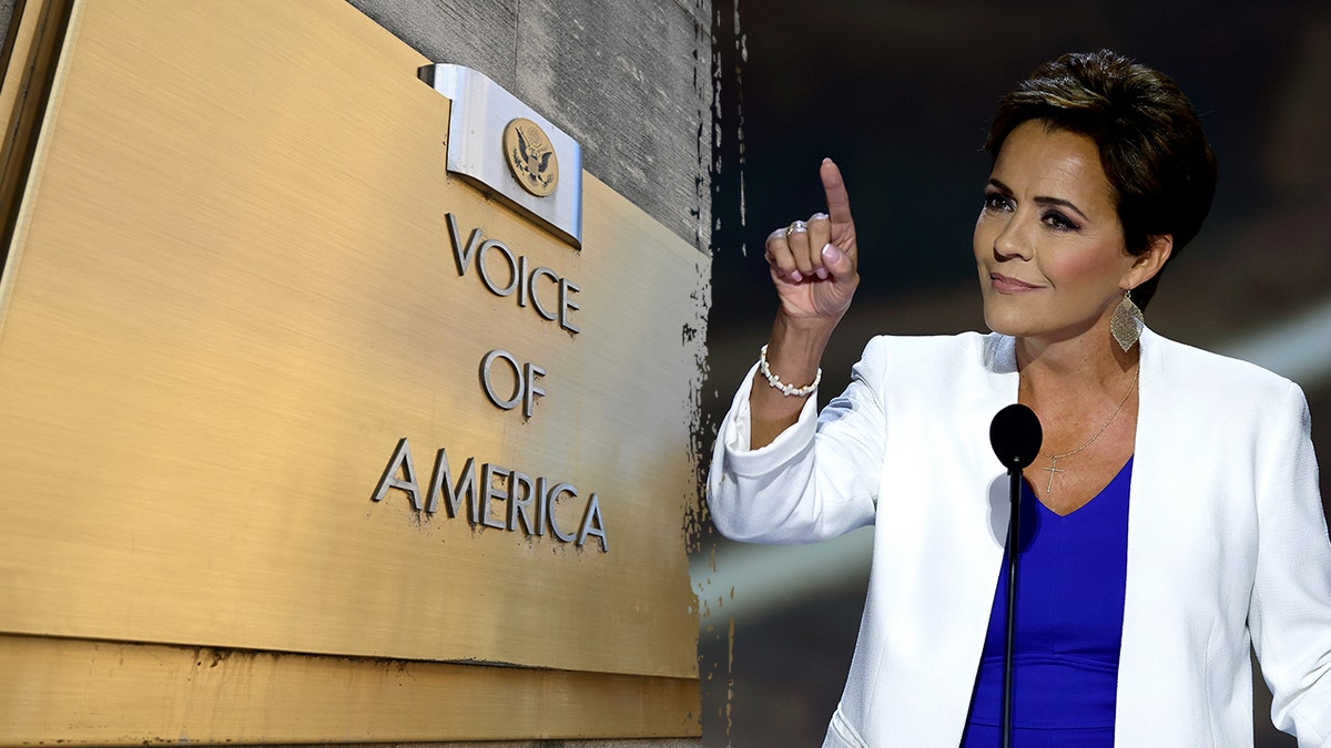Curry Lake fala em um pódio ao lado da placa de construção da Voice of America.