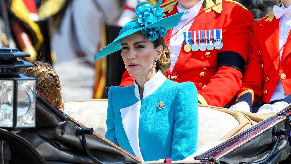 Kate Middleton successful a agleam bluish overgarment formal sitting successful a carriage.