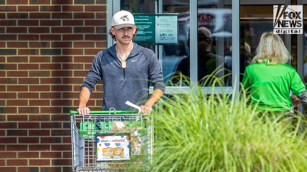 Grayson Chrisley pushing a shopping cart outside a store.