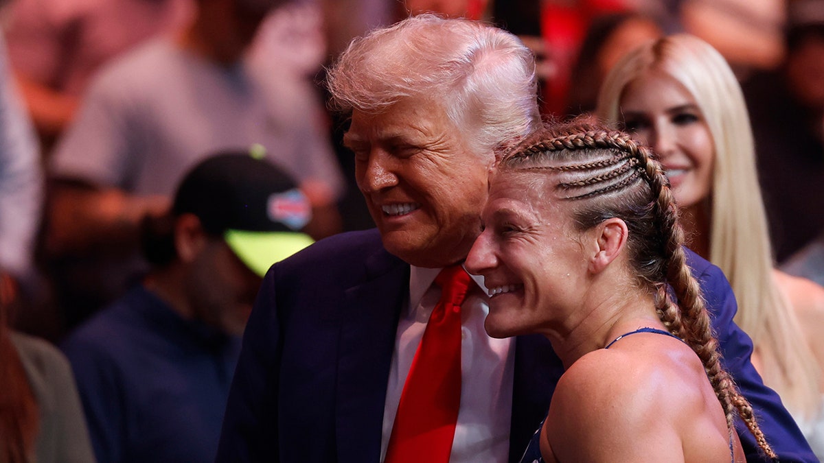 Kayla Harrison pozē fotoattēlam ar Trumpu
