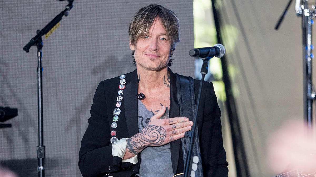 keith urban on stage with his hand over his heart