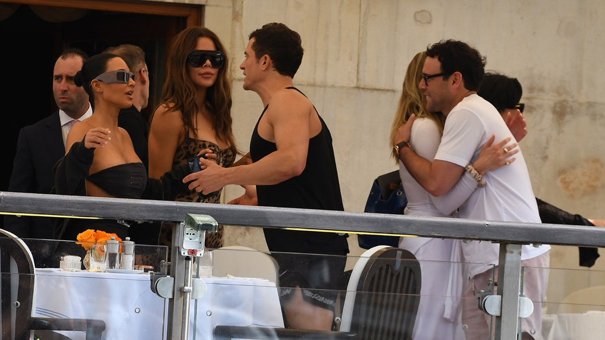 Orlando Bloom hugs Kim Kardashian.