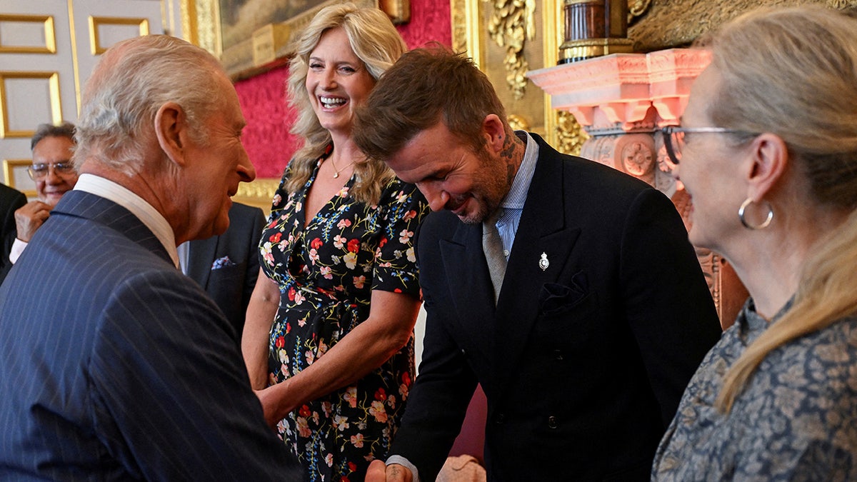David Beckham bowing to King Charles.
