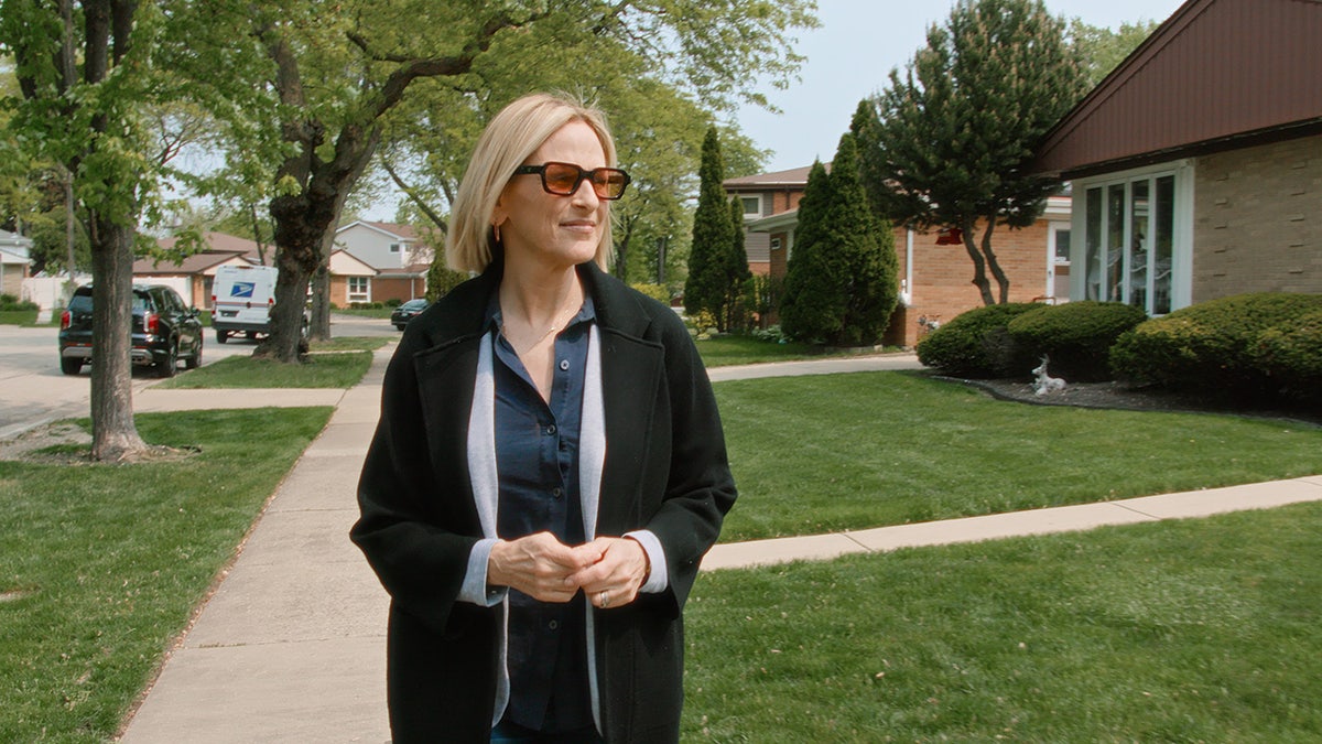 Marlee Matlin walking outside with sunglasses.