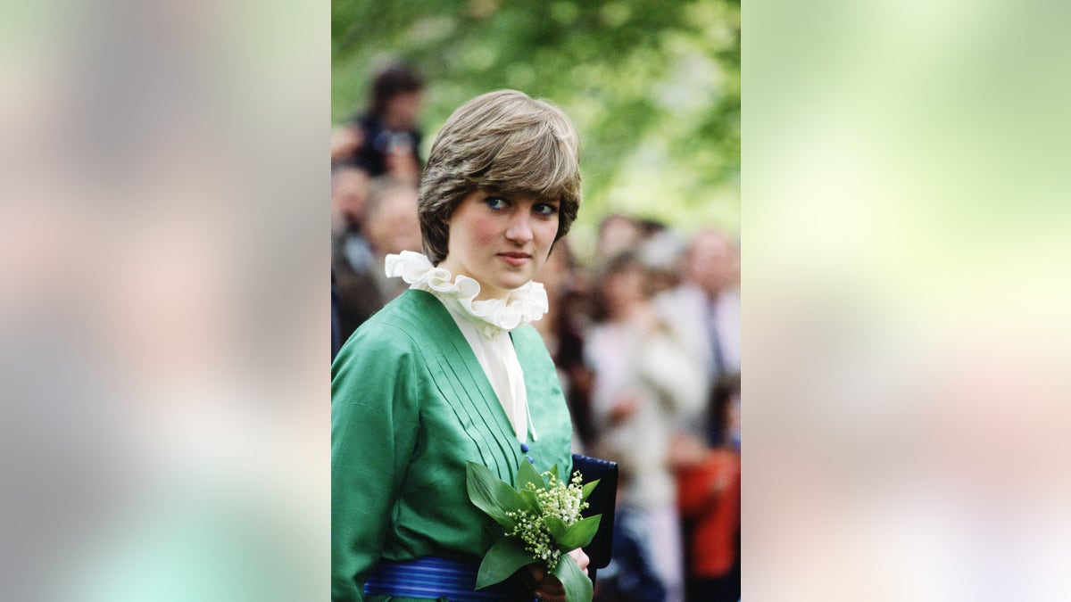 Princess Diana wearing a high neck frilly blouse with a