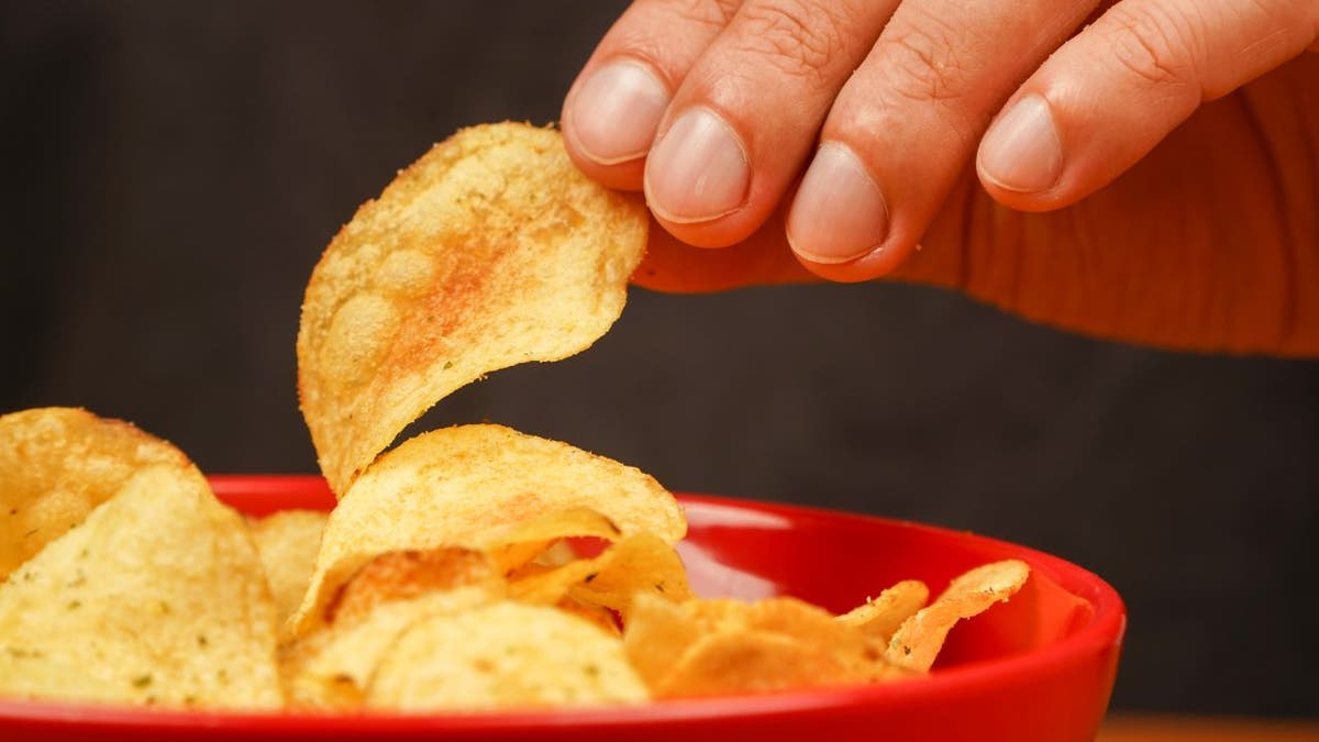 Person eating chips from bowl