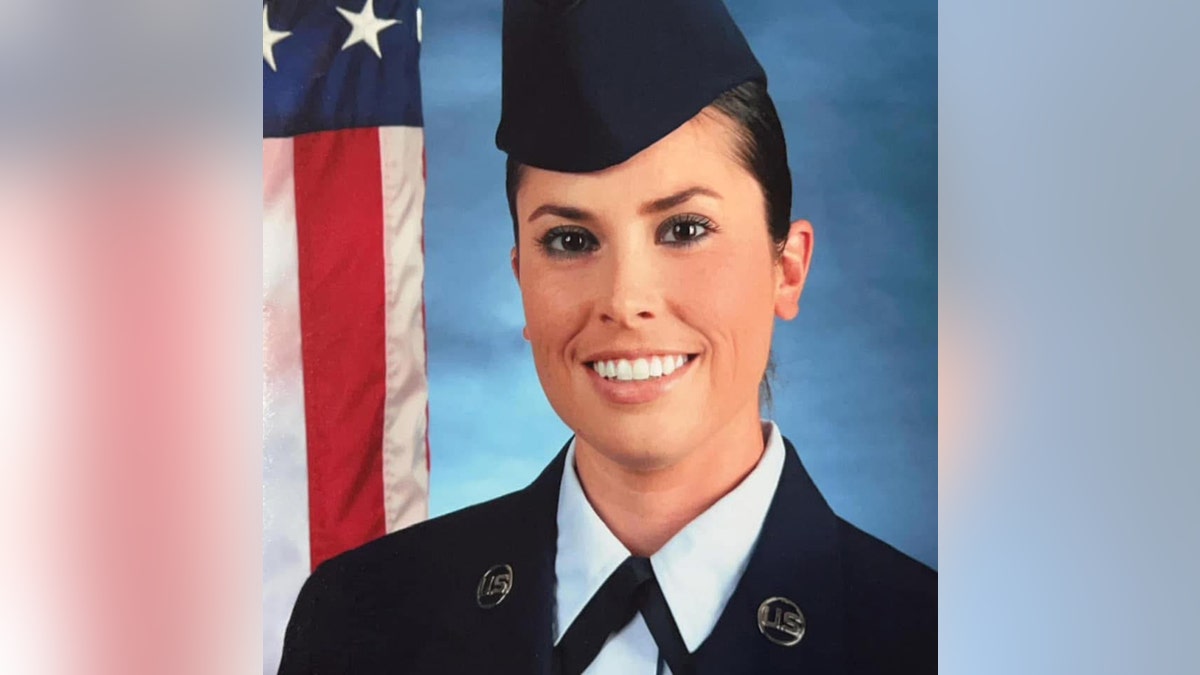 Lindsay Gutierrez in her uniform posing next to the American flag.