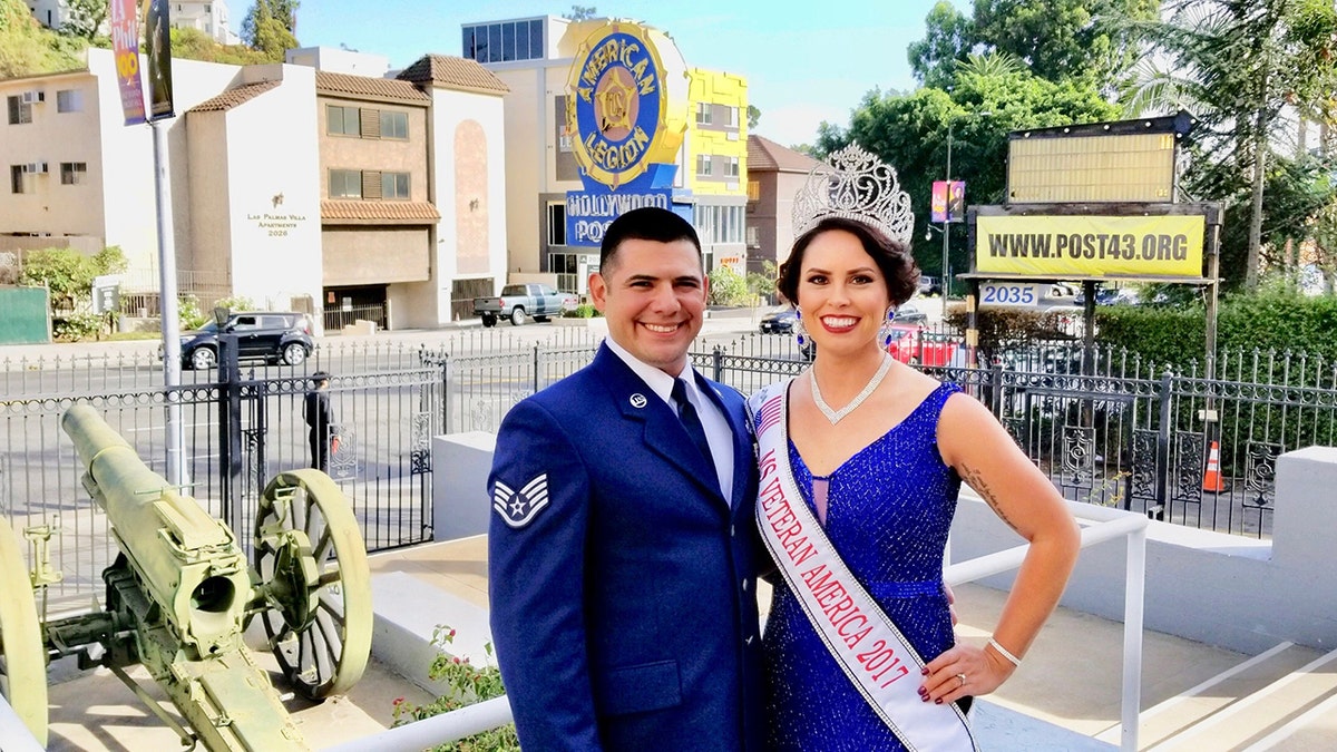Lindsay Gutierrez in a blue pageant gown with tiara posing next to her husband in a matching suit.