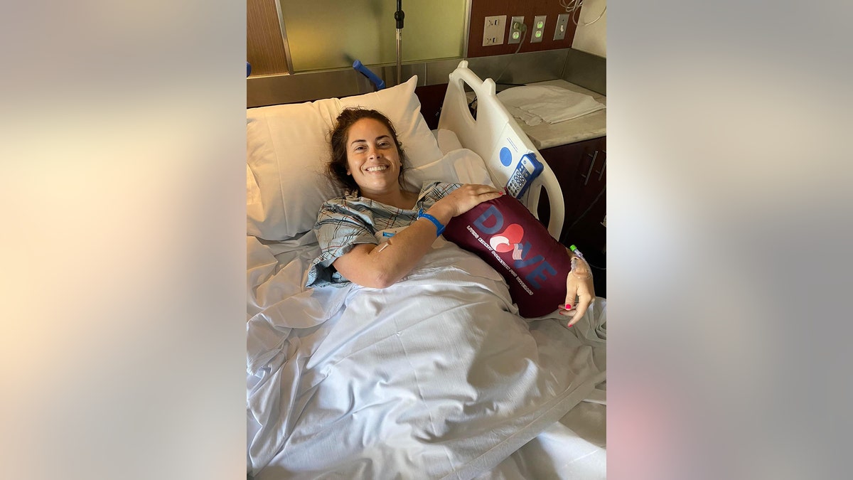 Lindsay Gutierrez laying on a hospital bed holding a pillow.