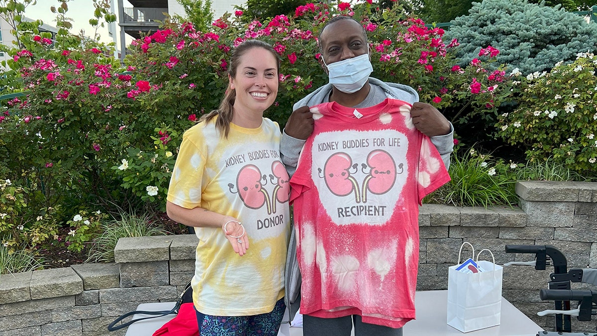 Lindsay Gutierrez posing with the man who received her organ as they're in matching shirts.
