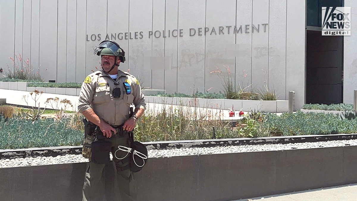 Los Angeles County Sheriff’s deputy stands guard outside LAPD headquarters amid civil unrest