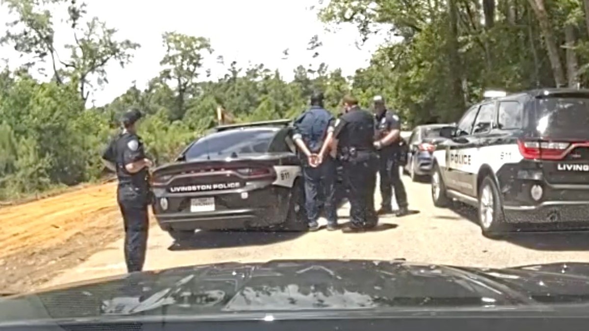 police arrest man in handcuffs, escort him to police car