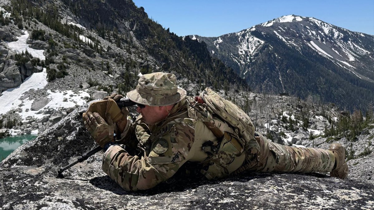 A U.S. Marshals members looking through a scope in the search for Travis Decker