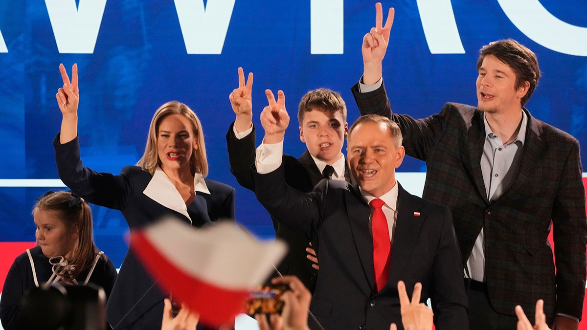Nawrocki and his family do the peace sign on stage