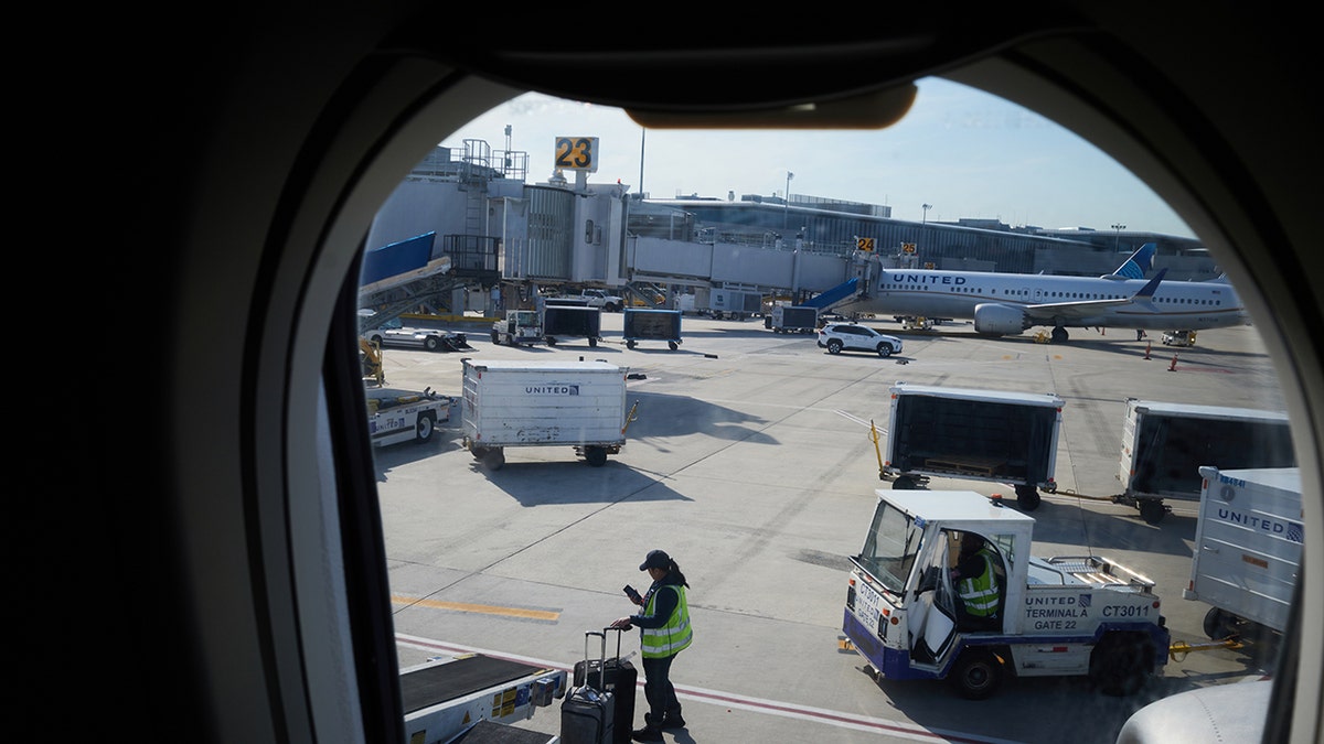 United Airlines crew loads bags onto plane at Newark