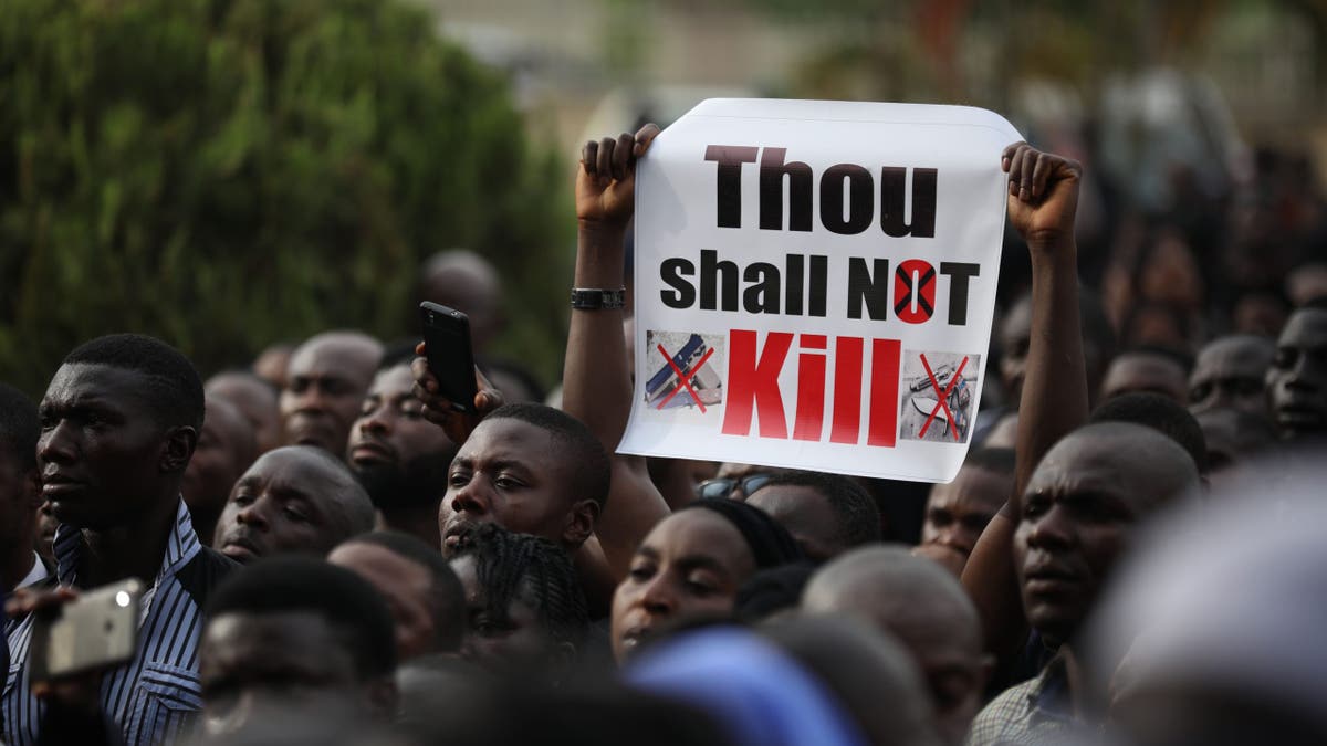 Christian faithful hold signs as they march on the streets of Abuja during a prayer and penance for peace and security in Nigeria on March 1, 2020.