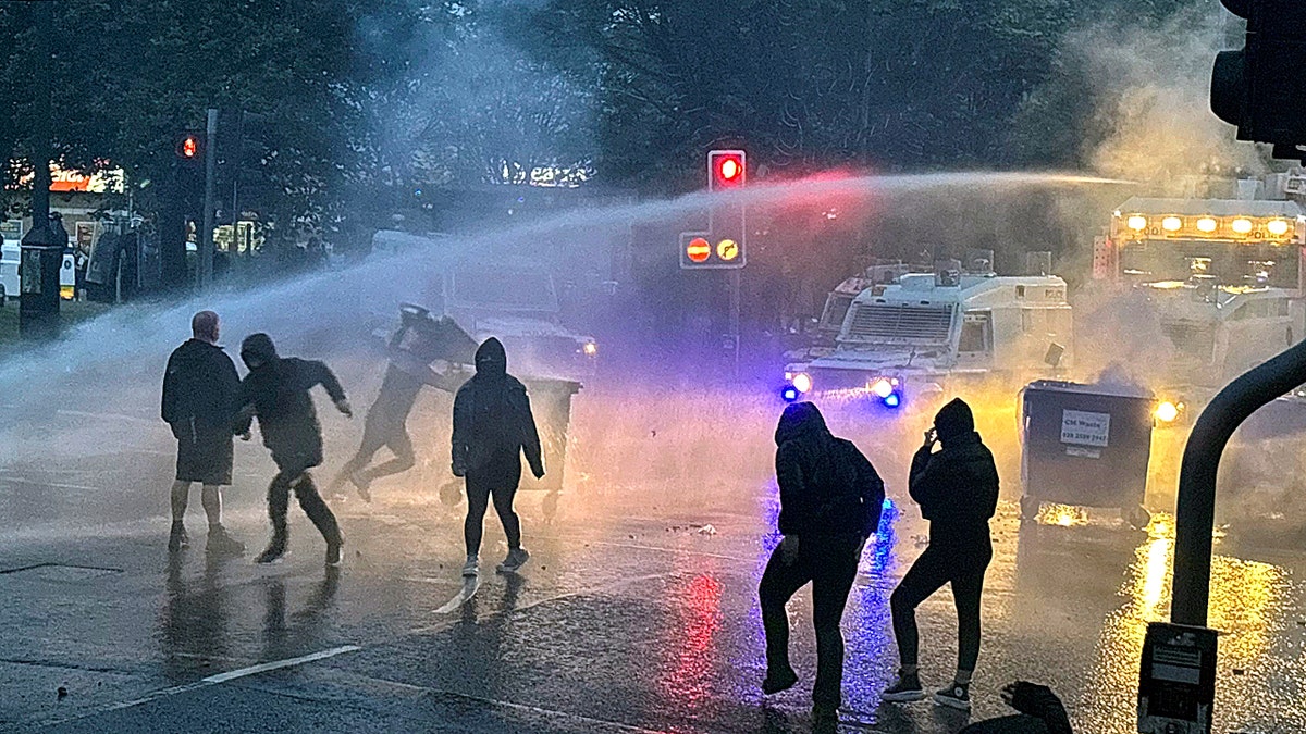 Protesters being sprayed with a water cannon