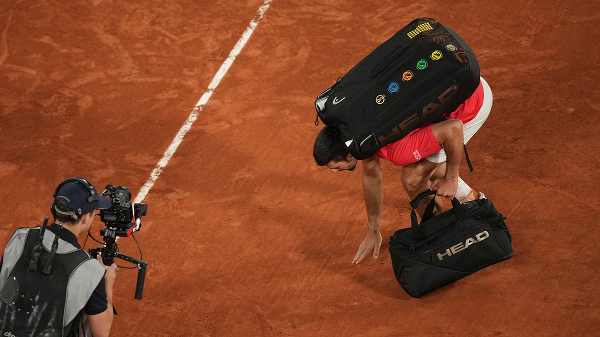 Novak Djokovic touches the ground
