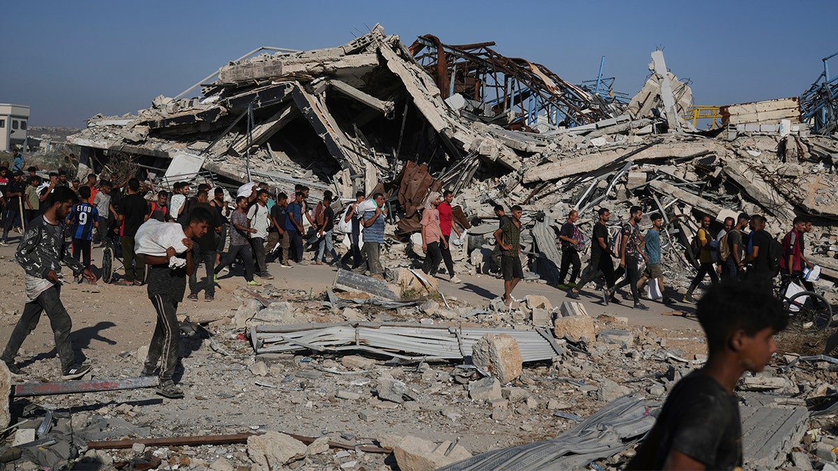 Palestinians carry aid packages distributed by the Gaza Humanitarian Foundation