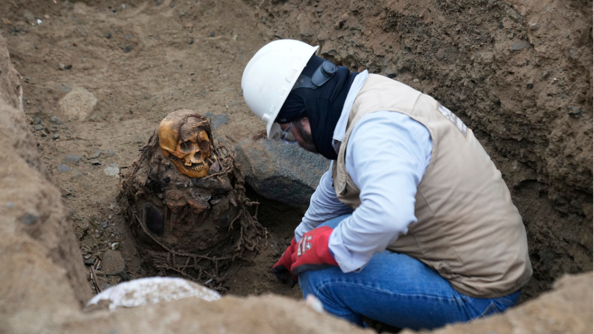 Worker next to mummy in ground