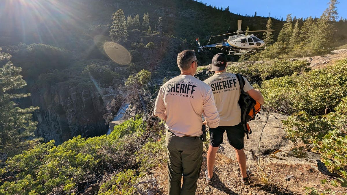 Law enforcement officer searching for three missing hikers