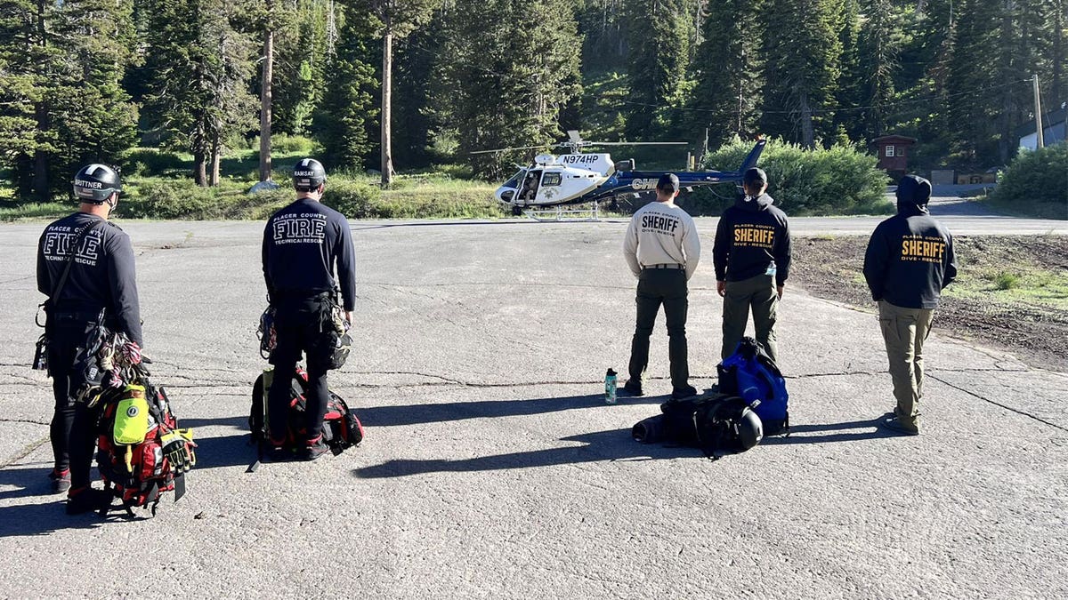Law enforcement officials look at a helicopter