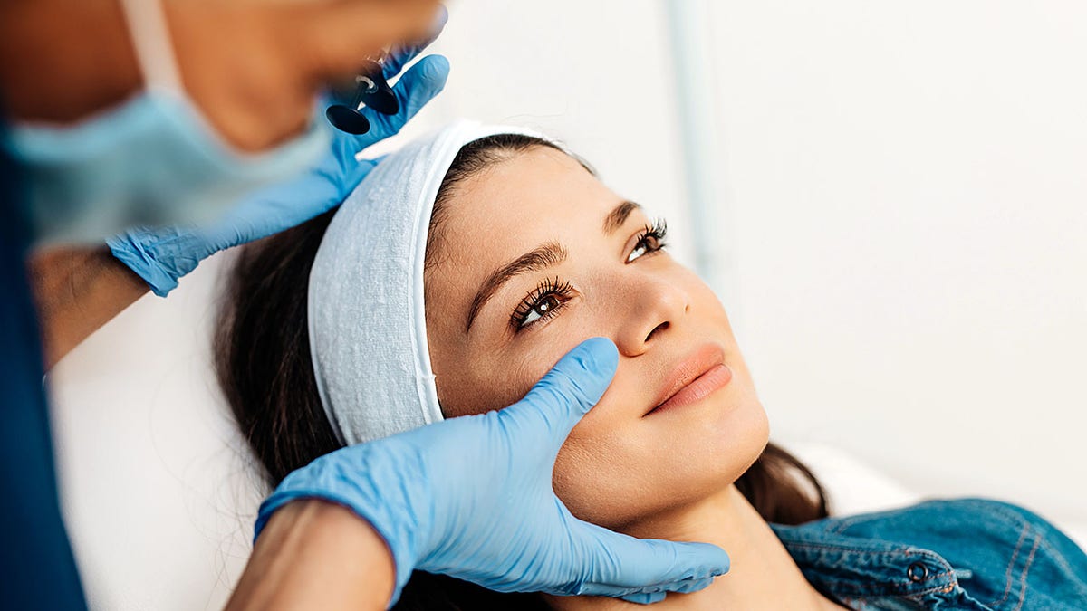 Facial aesthetics room treatment, female receiving integrative surgery
