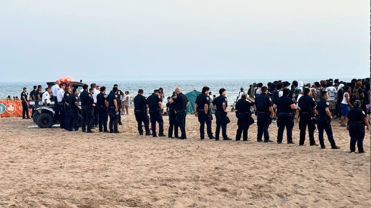Police form a barricade after brawls broke out at Coney Island Beach on Monday.