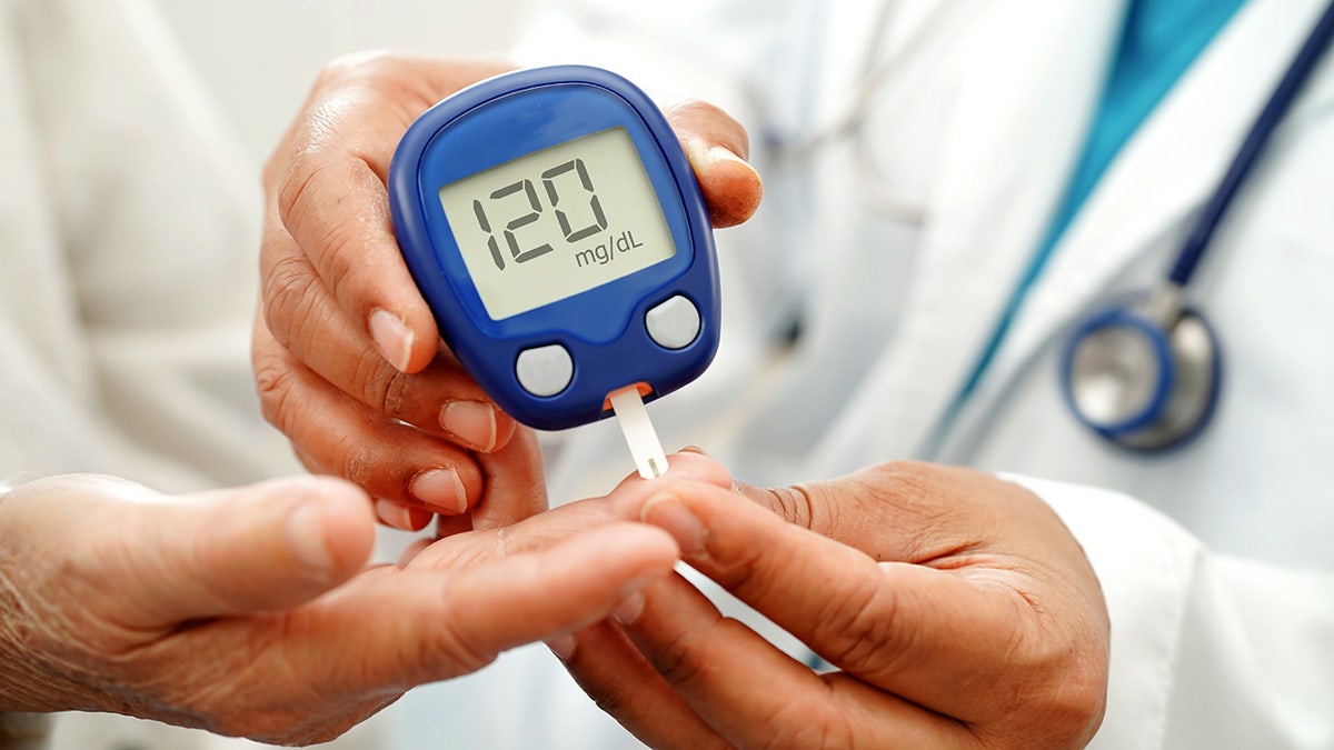 Asian doc utilizing integer glucose metre for cheque illustration humor sweetener level to attraction diabetes.
