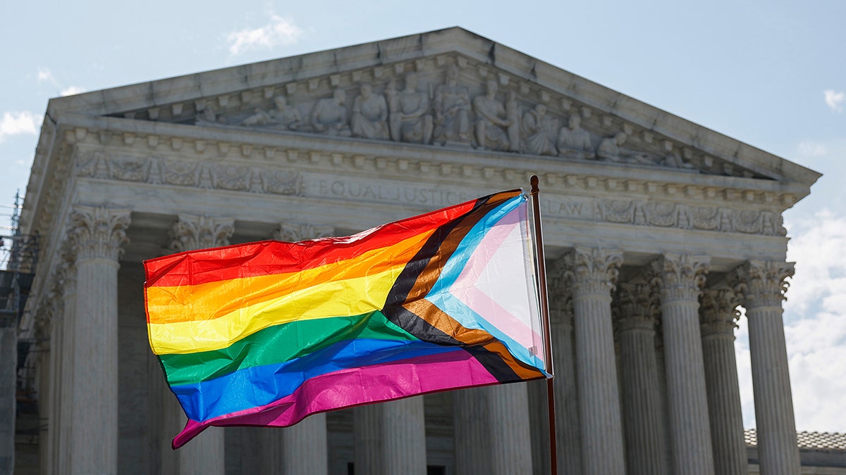 A bandeira do Pride LGBIAA está sendo engolida em frente à Suprema Corte