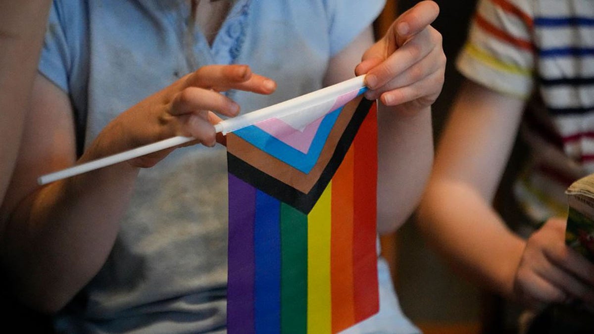 A student holding a pride flag