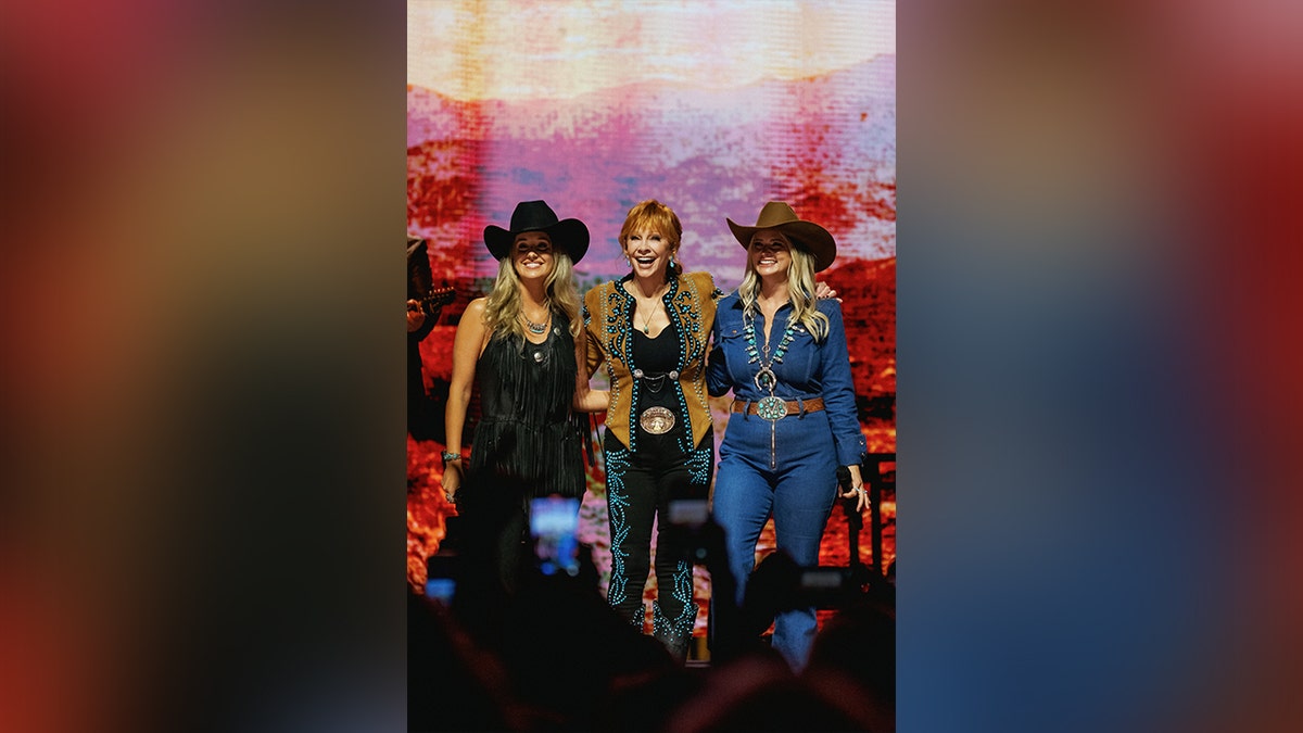 Reba McEntire, Lainey Wilson and Miranda Lambert on stage together.