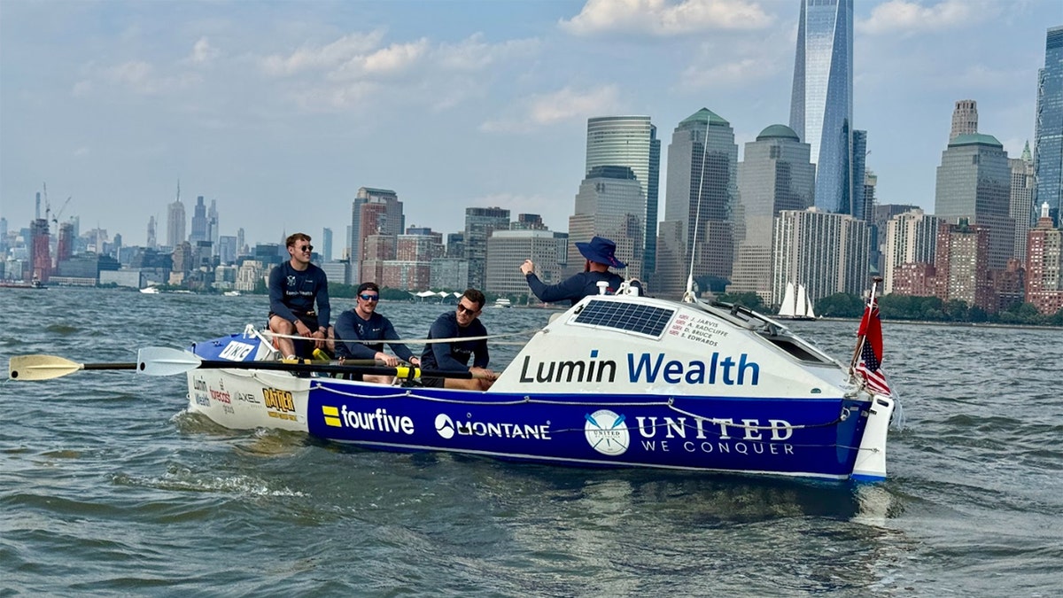 4-man rowing team on their boat in NY harbor