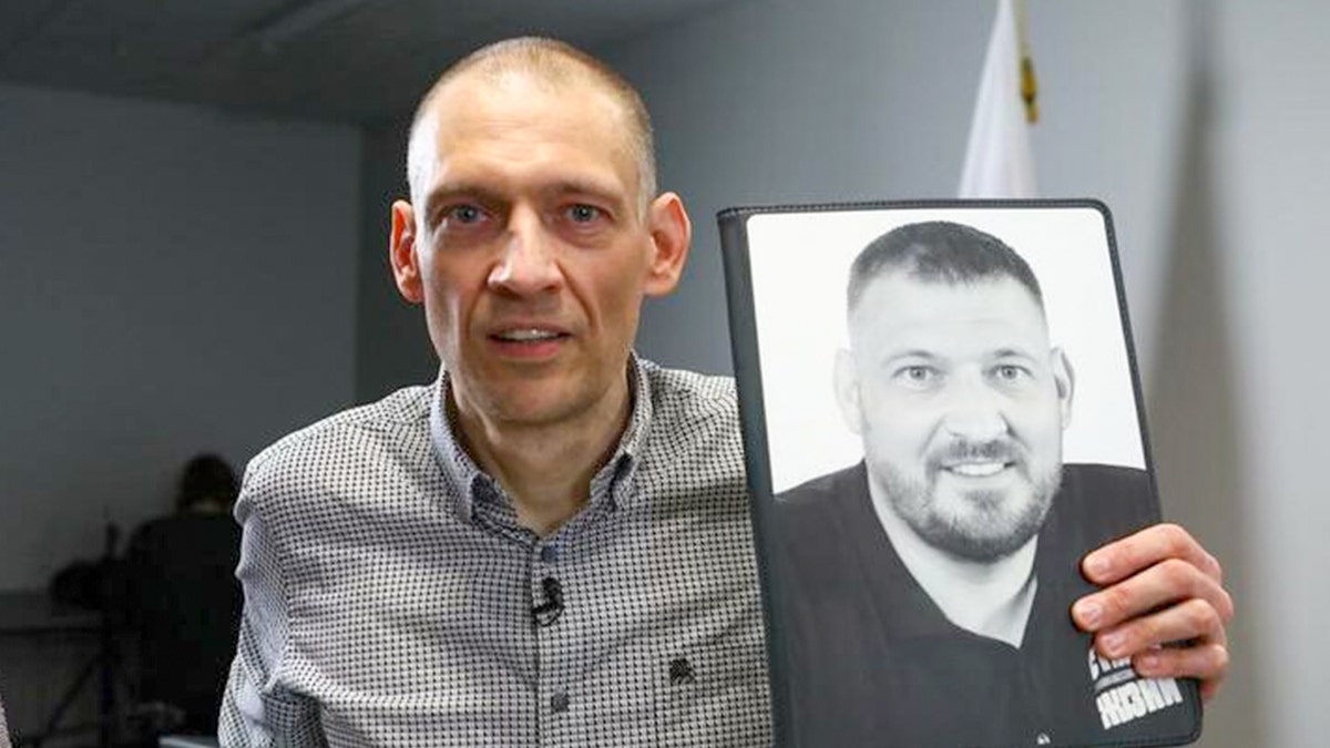 Siarhei Tsikhanouski holds a photo of himself prior to his detention