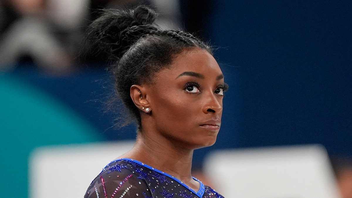 Simone Biles looks on
