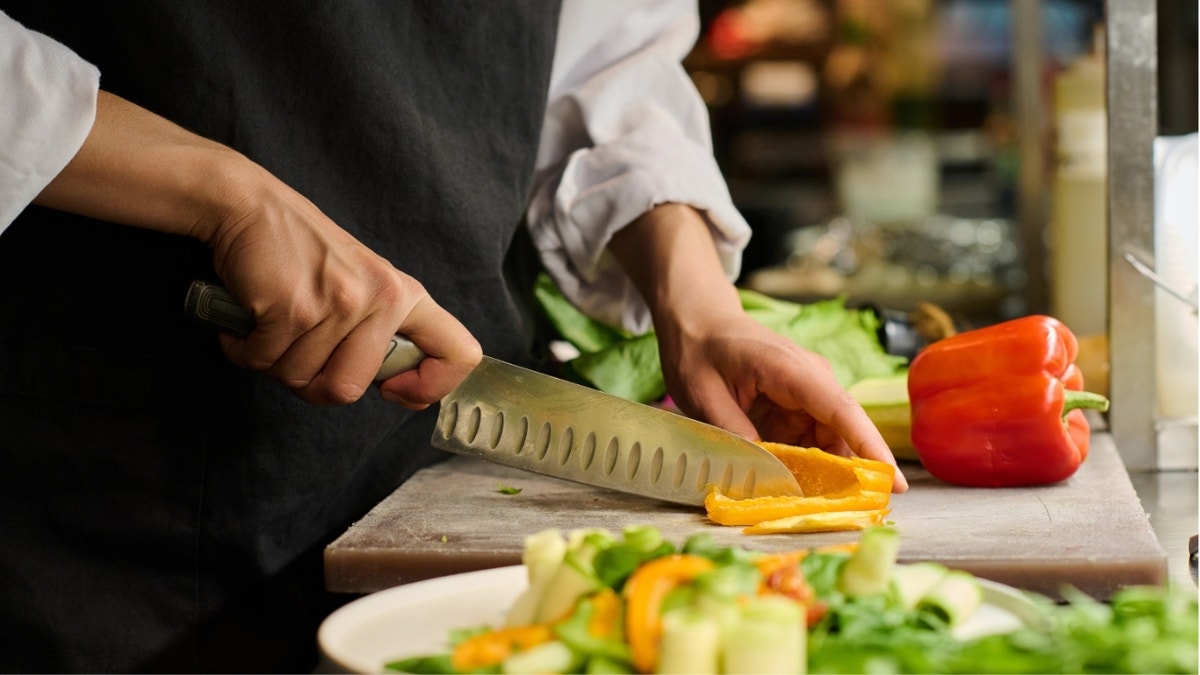 Hand chopping peppers on board