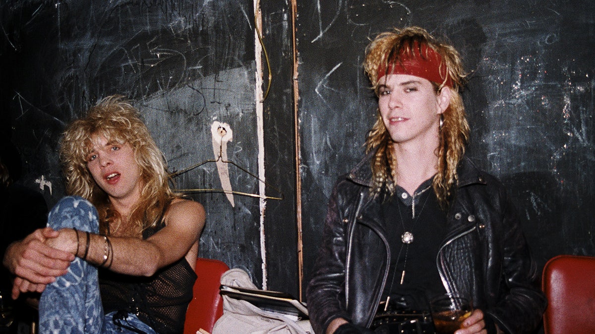 Steven Adler posing backstage aft a performance and smiling.